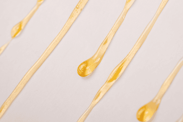 Image of rosin, a solventless concentrate, dripping down a parchment paper