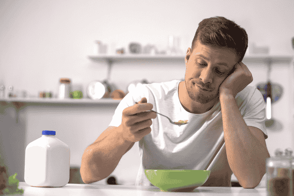 Picture of a man not wanting to eat his breakfast, implying the connection between THCV and appetite suppression
