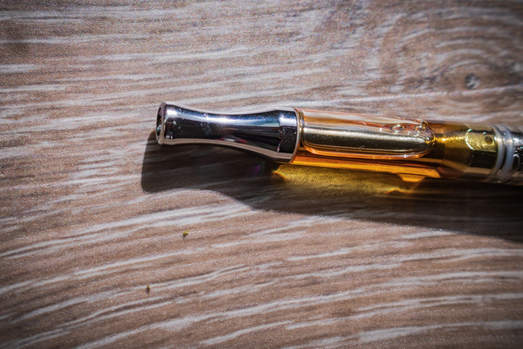 Image of a cannabis vape cartridge on a wooden surface
