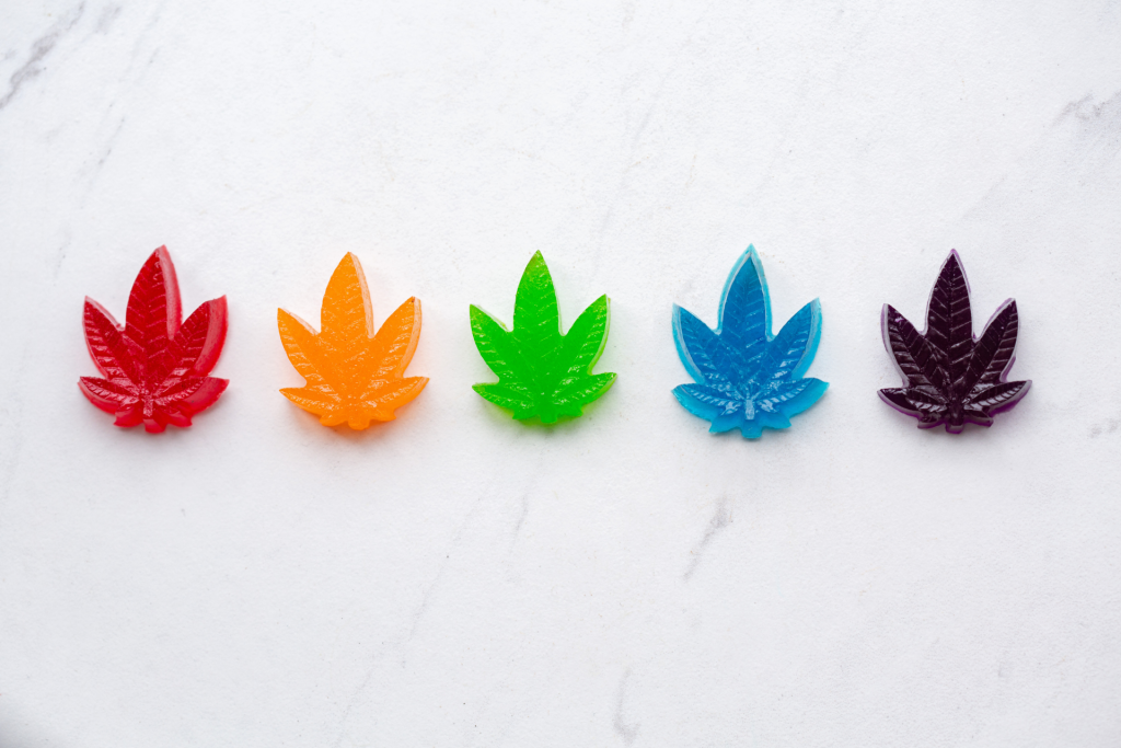 Sous vide cannabis edibles of various rainbow colors in the shape of weed leaves