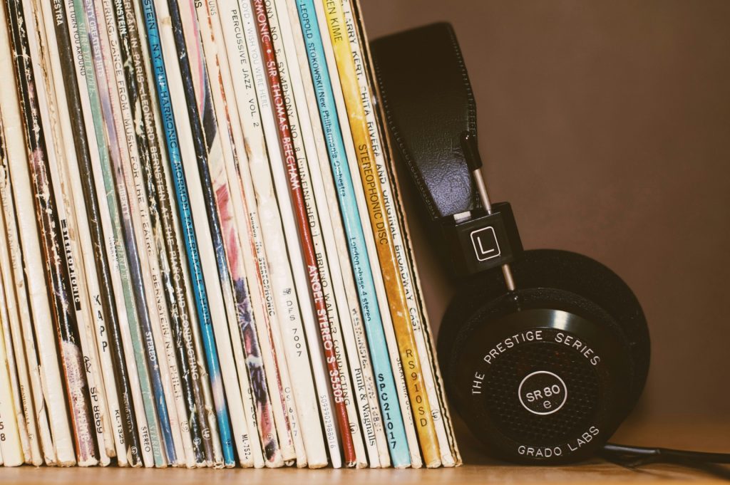 The impact of music on cannabis growth, visualized by a headphone resting up against a stack of vinyl records